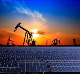 Oil pump with solar panels and the sunset