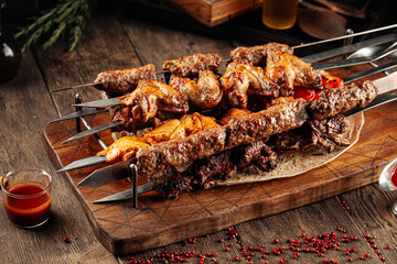 Assorted shashlik skewers with different meat on the wooden background