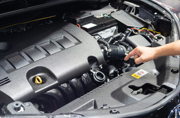 Hand point finger at engine interior of new car