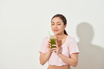 Young woman drinking green juice with straw