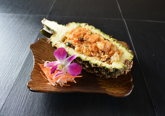 thai pineapple fried rice with seafood and meat in pineapple fruit in black background asian halal menu