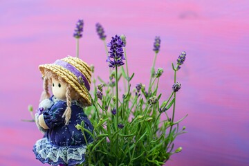 background of lavender flowers and doll in hat