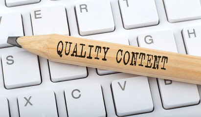 QUALITY CONTENT text on pencil on the keyboard background