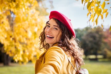 Poster Smiling happy woman looking behind in an autumn day © Rido