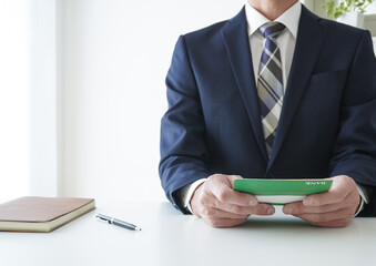 通帳を見るビジネスマン