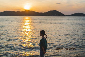 Fototapeta premium 夕暮れの海にいる女性