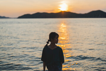 夕暮れの海にいる女性