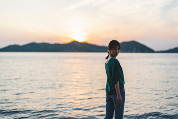 夕暮れの海にいる女性