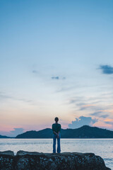 夕暮れの海にいる女性