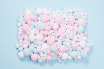 White, pink and blue soft pompons as a background.