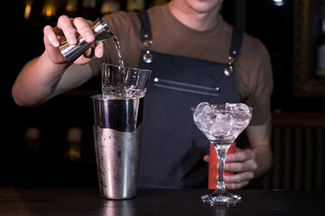 Close up hands of the bartender who make a margarita cocktail