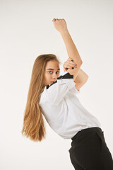 A girl in a white shirt stands on a white isolated background.