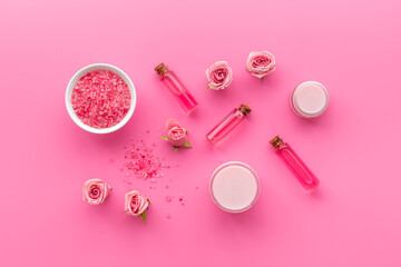 Flat lay of pink roses cosmetic with aroma oil and liquid for skin care