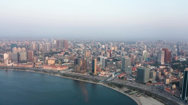 Traveling right, Luanda city, golden hour flying over Luanda bay, Africa