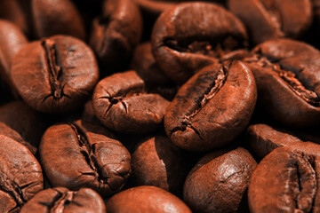 Natural coffee beans background. Macro. Texture of roasted gold colored coffee beans. Closeup.