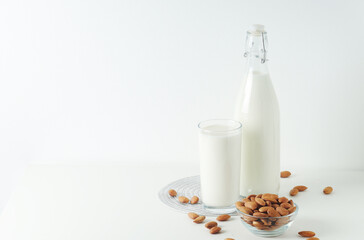 A glass with almond milk and the bowl with almonds