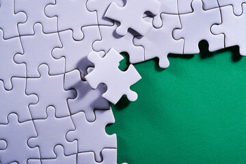 incompleted jigsaw puzzle on green background
