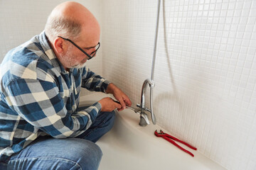 Plumber mounts faucet on the bathtub