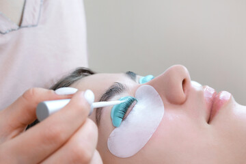 Young woman doing eyelash lamination procedure