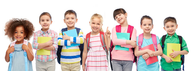 education, learning and people concept - group of happy smiling little children with school bags...
