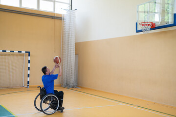 a war invalid in a wheelchair trains with a ball at a basketball club in training with professional...