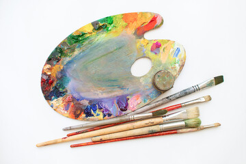 Palette oil paints, brushes on a white background. Place for text. Artist's workshop