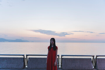 Fototapeta premium 夕暮れの海にいる女性