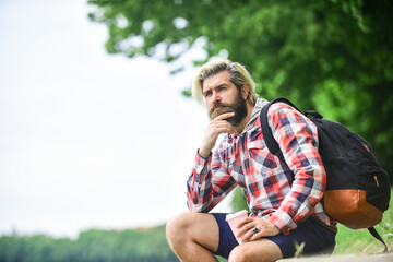 Naklejka na ściany i meble bearded hipster guy wearing casual clothes enjoys relaxing on weekend. morning drinks concept. student on coffee break. bearded man drinking coffee while sitting outdoors. copy space