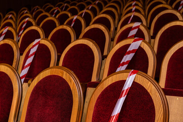 Restrictive tapes on the seats in the concert hall. Pandemic. Covid 19. Restrictive measures