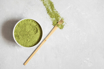 Green matcha tea powder on a gray background. Japanese traditional drink. Vegan healthy drink. View from above. Copy space.