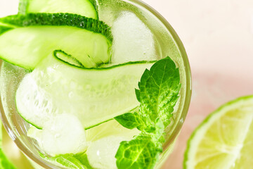 Close-up of the top of a glass with a garnish of fresh cucumber slices on summer detox and...