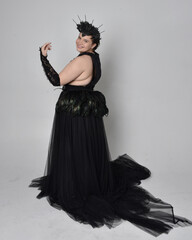 Full length portrait of young  plus sized woman with short  hair,  wearing long black tulle gothic...
