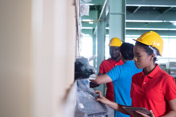 Woman Warehouse worker using digital tablet checking goods and supplies on shelves in a large warehouse.