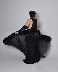 Full length portrait of young  plus sized woman with short  hair,  wearing long black tulle gothic...