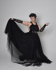 Full length portrait of young  plus sized woman with short  hair,  wearing long black tulle gothic...