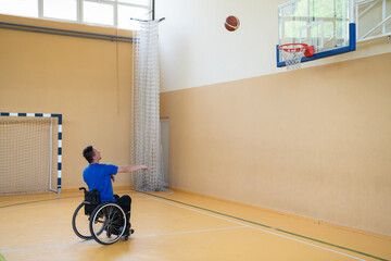 a war invalid in a wheelchair trains with a ball at a basketball club in training with professional...