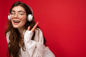 Photo of beautiful happy smiling young brunette woman wearing white shirt and optical glasses...