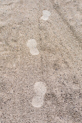 Multiple footprints on wet sand after rain. Footprints in the wet sand. Sand background.