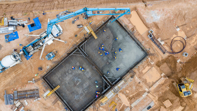 Generative AI Arial view construction worker pouring concrete at construction site  