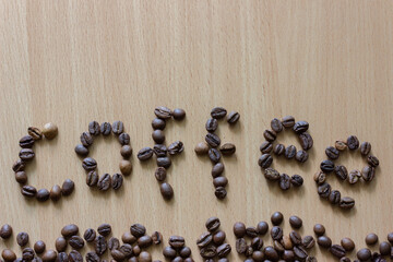 Coffee beans on wooden background. Word 