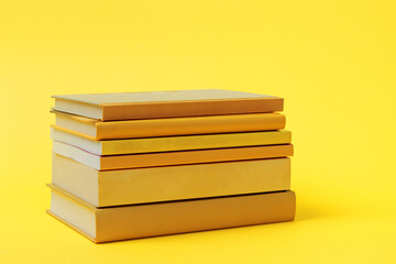 Stack of yellow books on yellow background. Education concept.