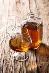 Cognac or whiskey drink on rustic wooden table. 