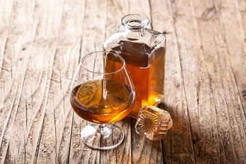 Cognac or whiskey drink on rustic wooden table. 