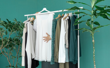 middle aged woman shopping new dress clothes shelf green