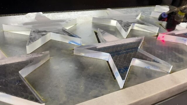 Laser machine carves glass stars from organic glass in the production of souvenirs