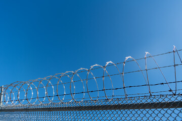 barbwire prison wall with barbed wire fence coiled razor wire perimeter fence, barbed fence.