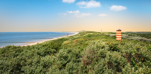 Fototapeta na wymiar Panoramic coastal landscape with lighthouse in the dunes at the beautiful beach of Dishoek, Zeeland, The Netherlands.