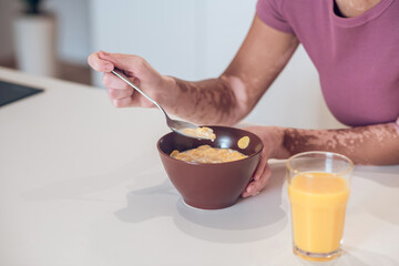 Obraz na płótnie Canvas Dark-skinned young woman having breakfast at home