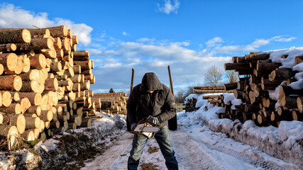 man with a chainsaw at logging