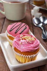 Strawberry cupcakes on a wooden background. Strawberry yogurt cupcakes for tea. Sweets with tea.